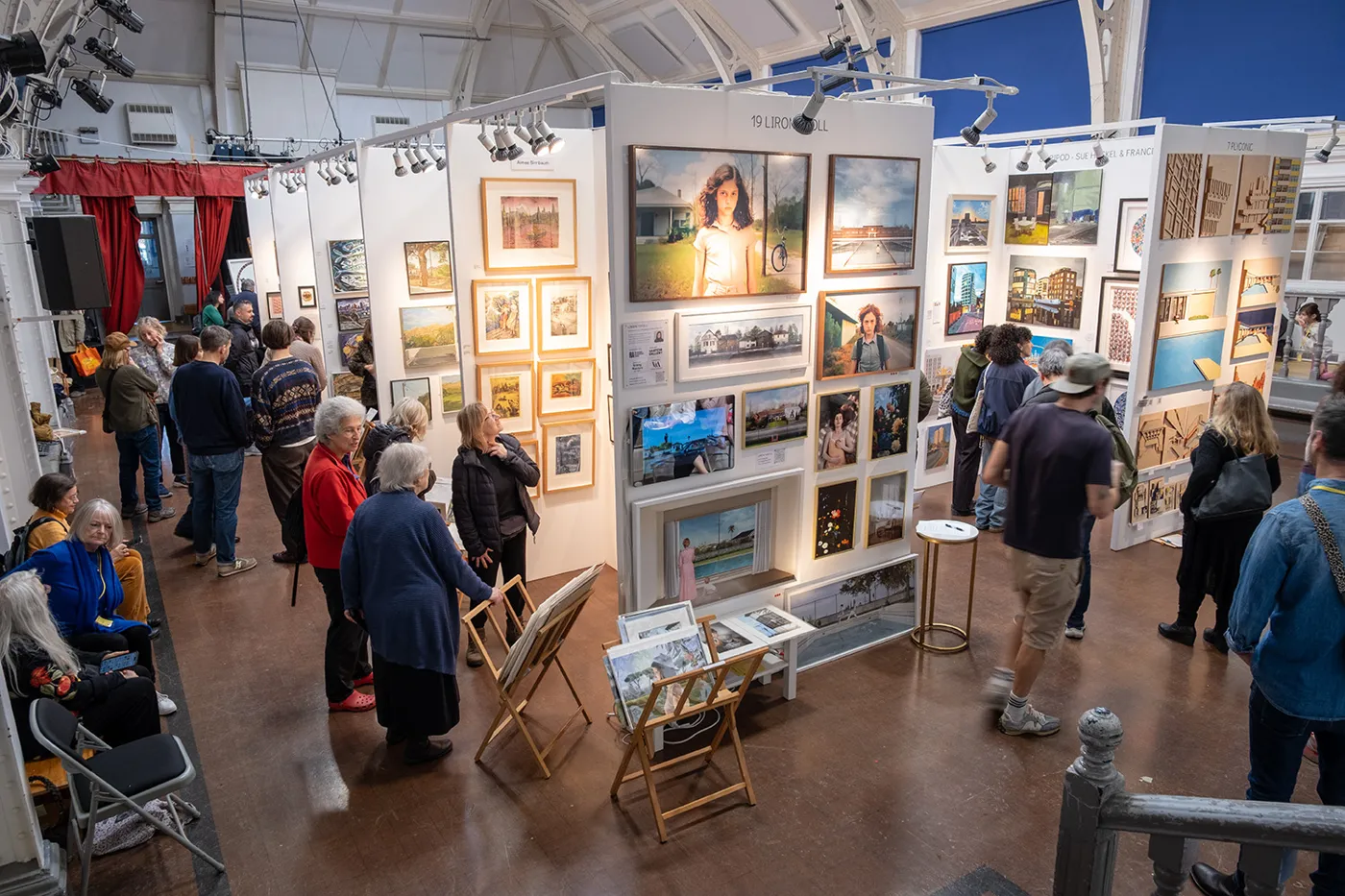 A busy hall seen from above, with visitors moving between display stands